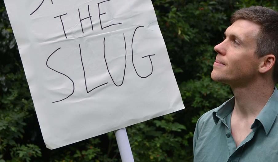 Simon Watt holding a sign saying "Save the Slug".
