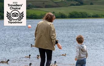 A mother and child feeding ducks at Hollingworth Lake.