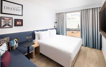 Double bedroom featuring desk, sofa and double bed in Hampton by Hilton - Rochdale