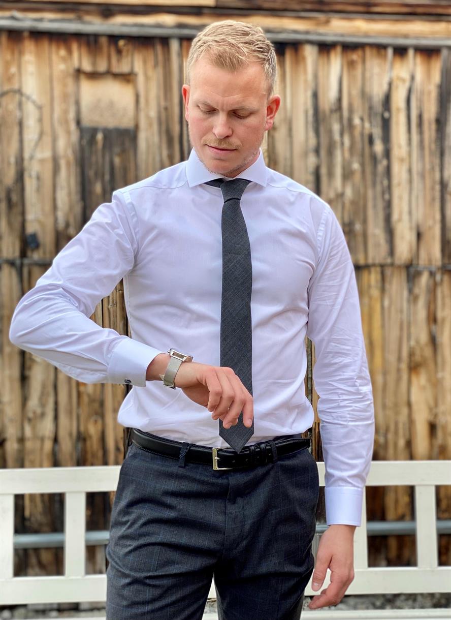 Pent kledd mann ser på armbåndsuret. Klar for bryllup