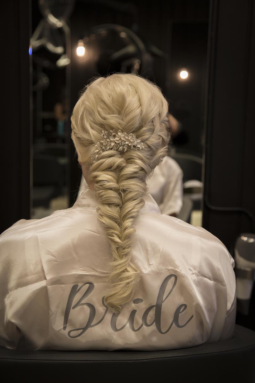 Nærbilde av brudeflette bakfra. Bruden er hos frisøren.