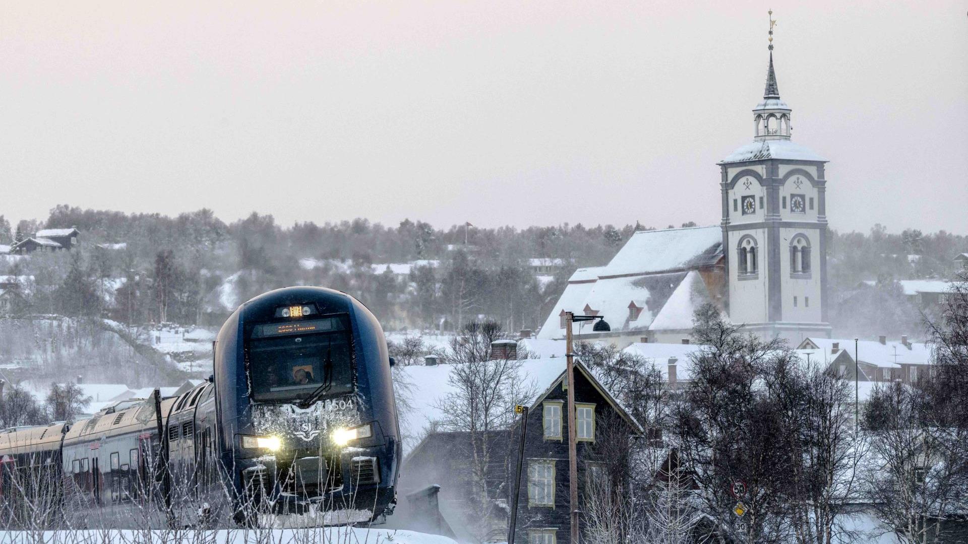 Tog med Røros kirke i bakgrunnen vinterstid