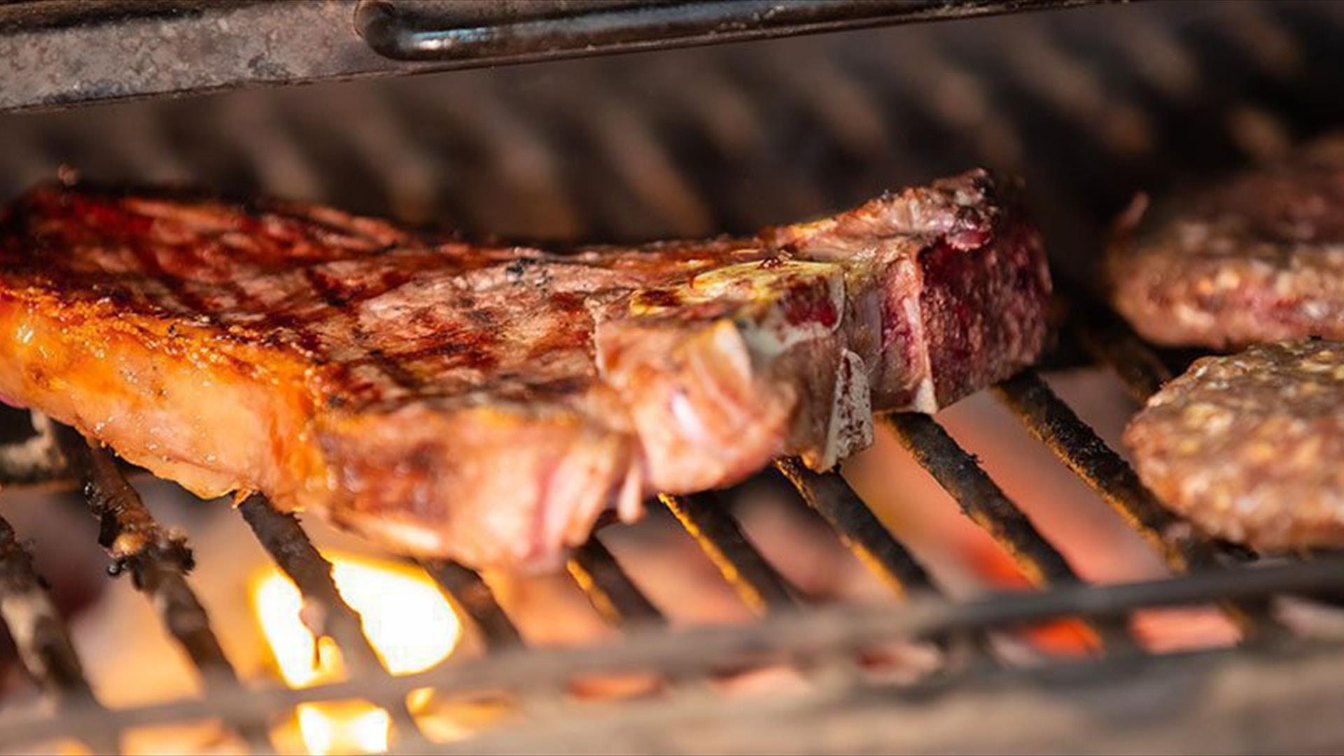 Kjøtt stekes over grillen på Grillhuset Røros