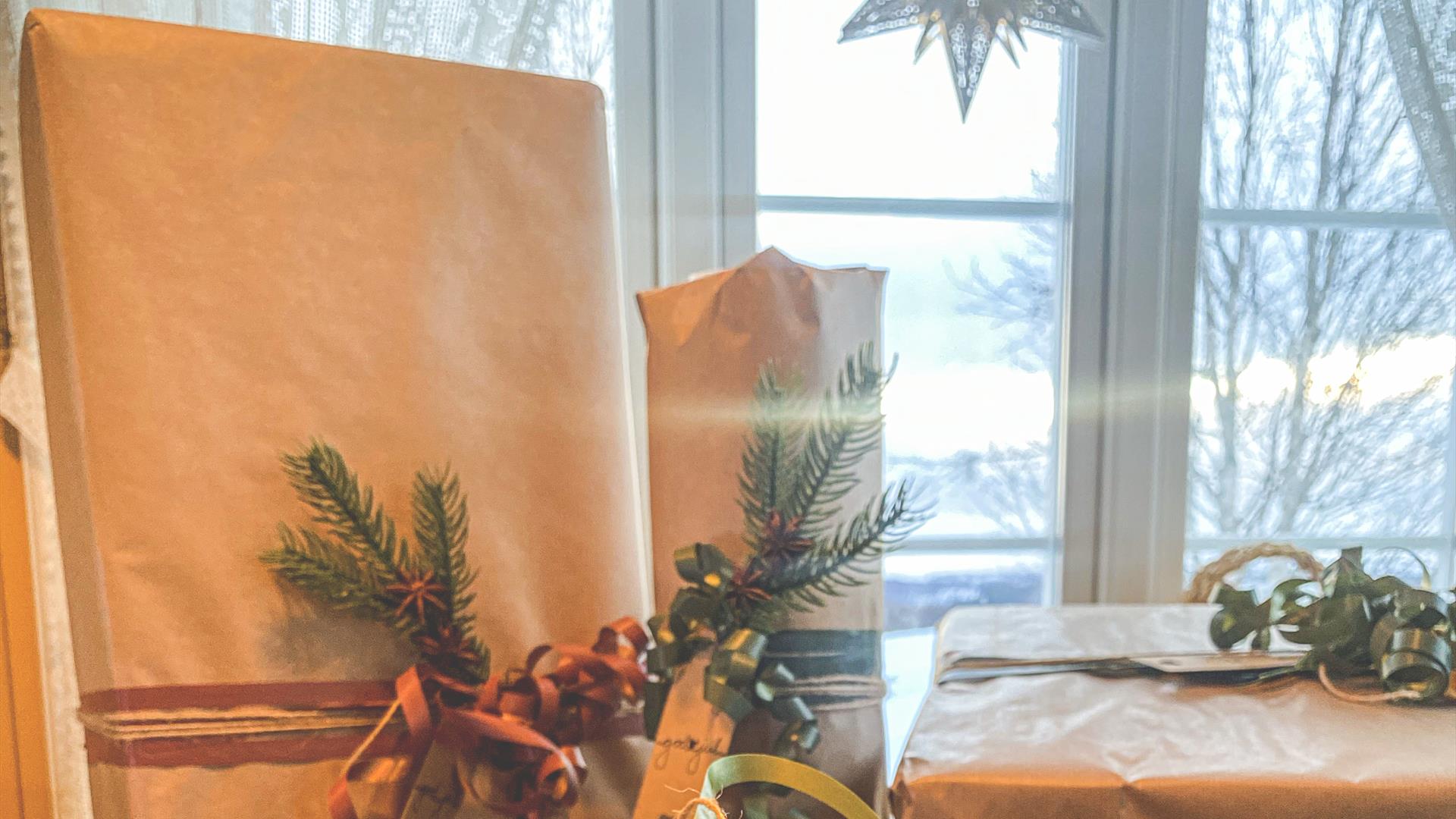 Julestemning med pakker og adventsstjerne i vinduet