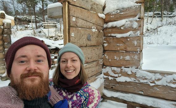 Ungt par som bygger tømmerhus