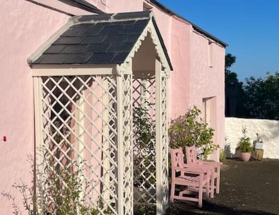 Outside view of the pink cottage with trellis porch