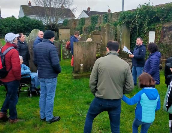 Alastair Donaghy leading a Ballymena Walking Tour with tour participants standing in a graveyard