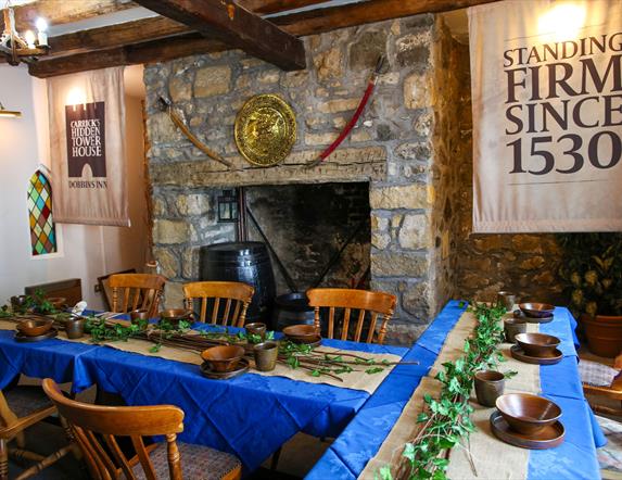 Room set up for Dobbins dining experiece as part of Dobbins Dander and Dine with seats and long tables in front of a large fireplace.