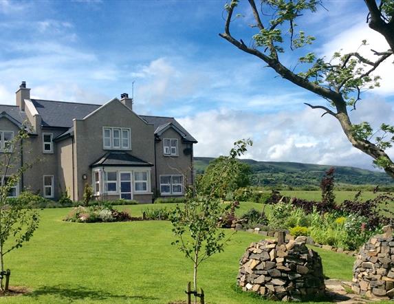 View of BallyCairn House from front garden. Situated on an elevated, picturesque location overlooking the Irish Sea with backdrop views of the Antrim