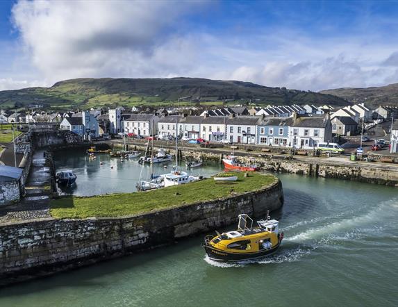 Curiosity boat leaving historical Carnlough harbour