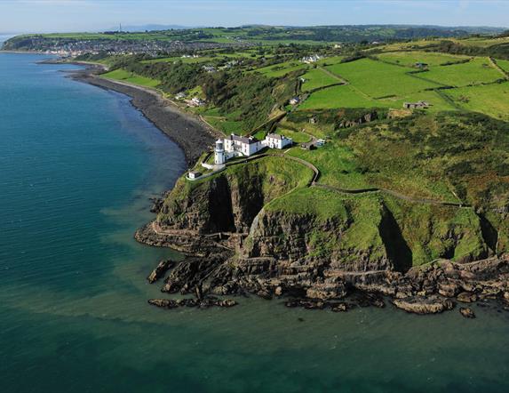 Aerial view of Blackhead Coastal Path and Lighthouse with surrounding countryside