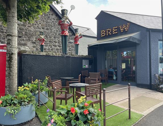 Exterior of Brew Coffee Shop with seating area and herald trumpeters