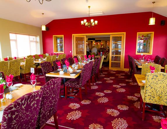 Dining area within Curran Court Hotel restaurant with a purple and pink decor.