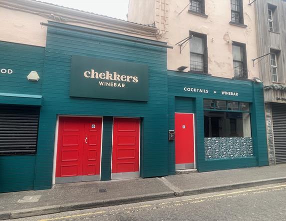 Teal Green exterior of Chekkers Wine Bar with red doors