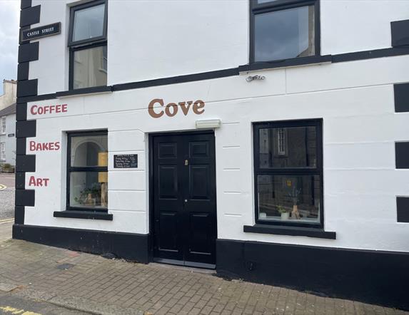 Black and White exterior of Cove Coffee Shop with words painted for Coffee Bakes and Art