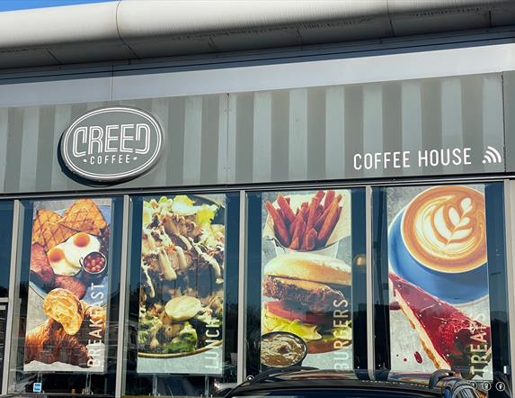 Exterior of Creed Coffee House in Carrickfergus with banners in windows displaying food options