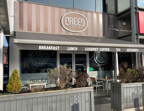 Exterior of Creed Coffee in Larne with outdoor seating area, and grey canopy