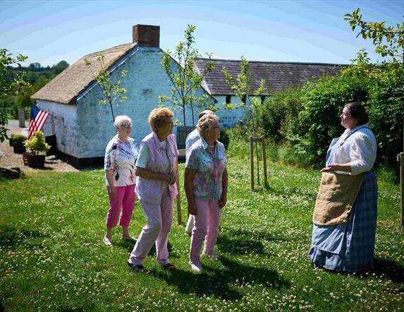 Group of people walking through garden at Arthur Cottage