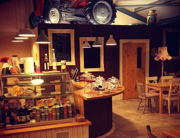 Serving counter in EJ's Country Kitchen in Hillstown, with drinks fridge to the front of the counter and display cases on the counter for scones, bake