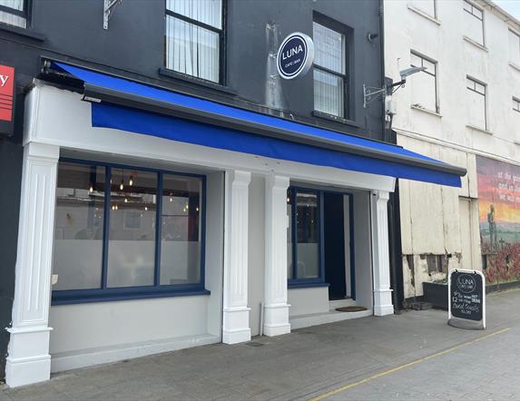 Exterior of Luna Cafe / Bar in Carrickfergus with blue canopy and white pillars