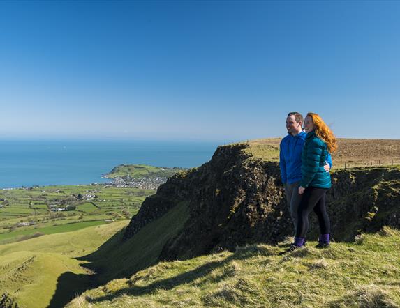 Walkers looking over cliff top at Sallagh Braes