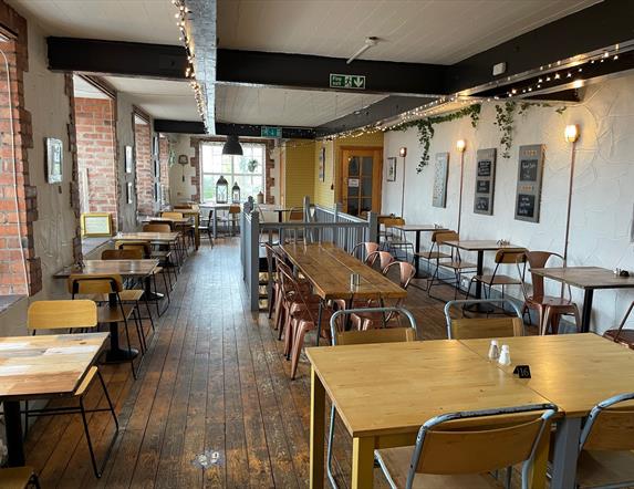 Interior of Season Coffee Shop with wooden flooring, wooden beams and wooden tables plus chairs.