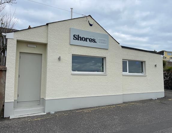 White exterior of Shores. Whitehead with windows facing onto Whitehead promenade.