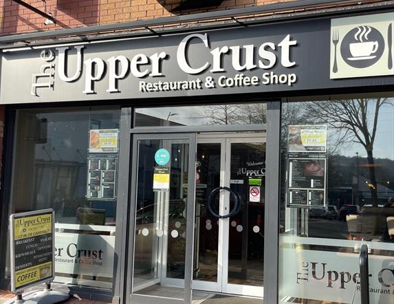 Exterior of Upper Crust restaurant and coffee shop with entrance doors and windows