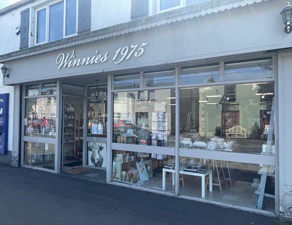 Grey exterior of Winnies 1975 with large window displays