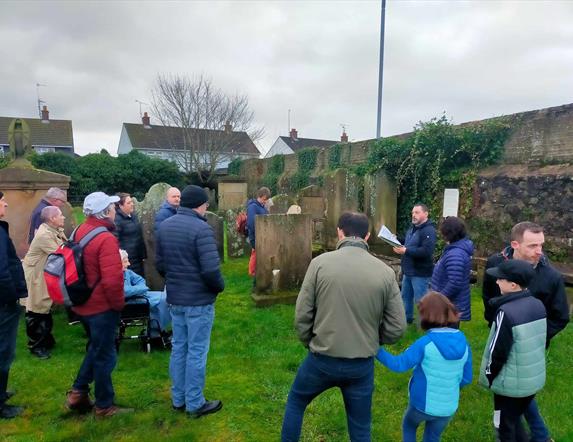 Alastair Donaghy leading a Ballymena Walking Tour with tour participants standing in a graveyard