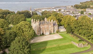 Aerial view of Glenarm Castle & Gardens with the ocean beyond.