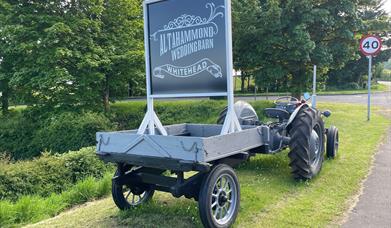 Vintage grey tractor with sign to rear stating Altahammond Wedding Barn