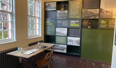 Interior of the Guard Room with information panels on wall and desk with Visitor Book