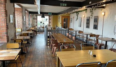 Interior of Season Coffee Shop with wooden flooring, wooden beams and wooden tables plus chairs.