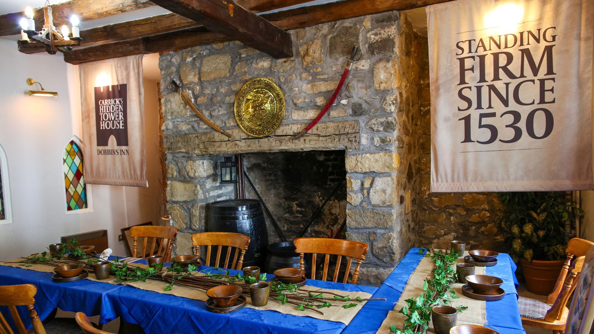 Room set up for Dobbins dining experiece as part of Dobbins Dander and Dine with seats and long tables in front of a large fireplace.