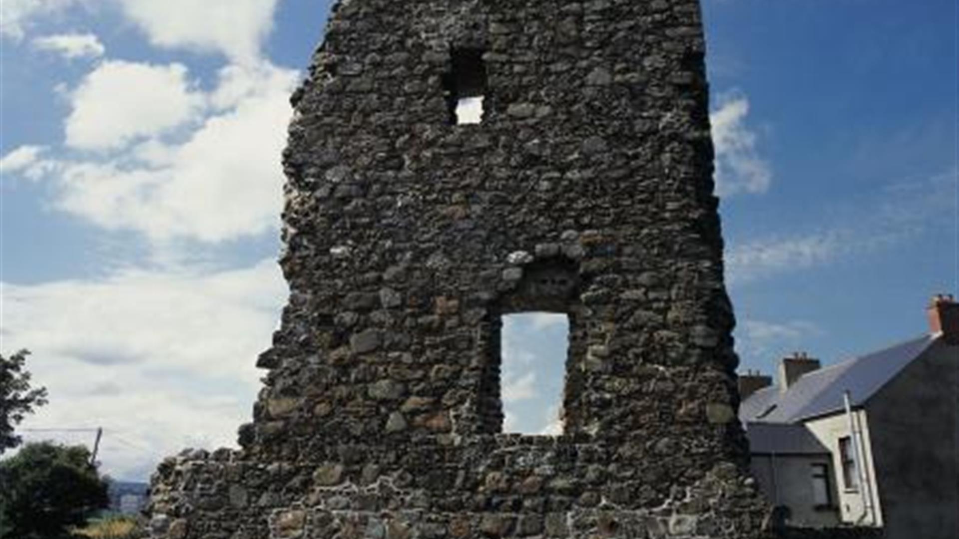 Ruined stone tower with large openings, under a partly cloudy sky.