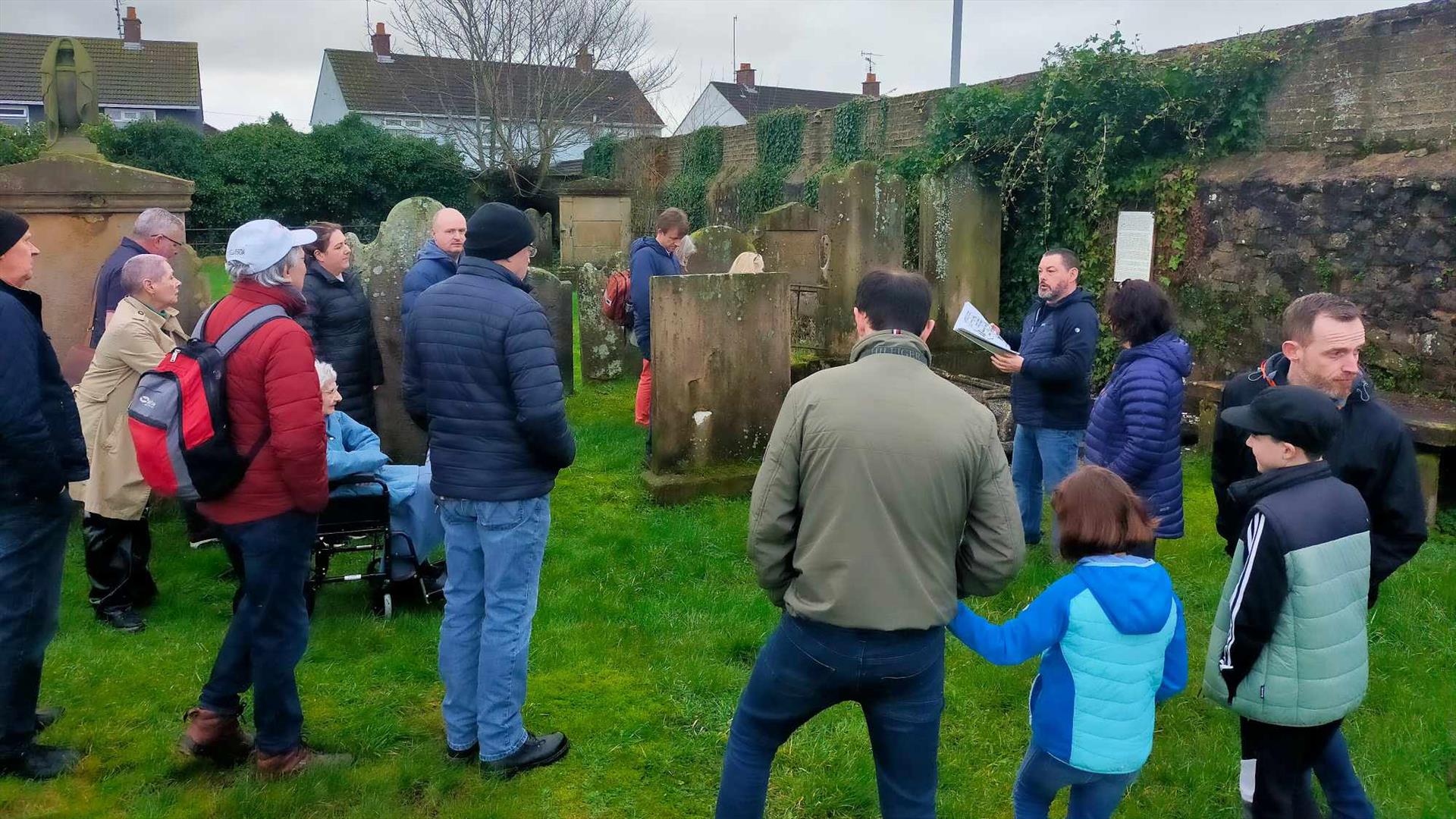 Alastair Donaghy leading a Ballymena Walking Tour with tour participants standing in a graveyard