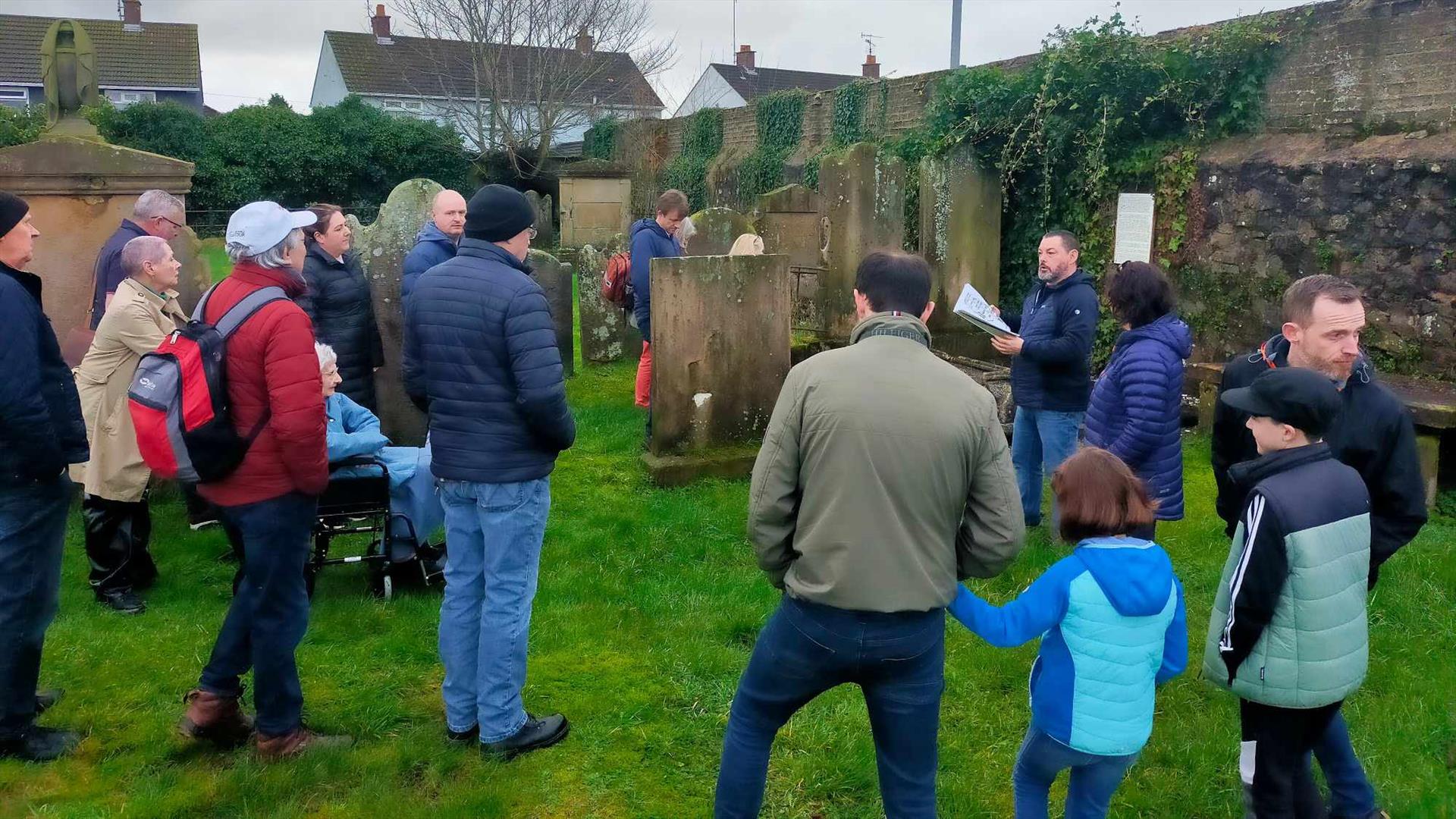 Alastair Donaghy leading a Ballymena Walking Tour with tour participants standing in a graveyard