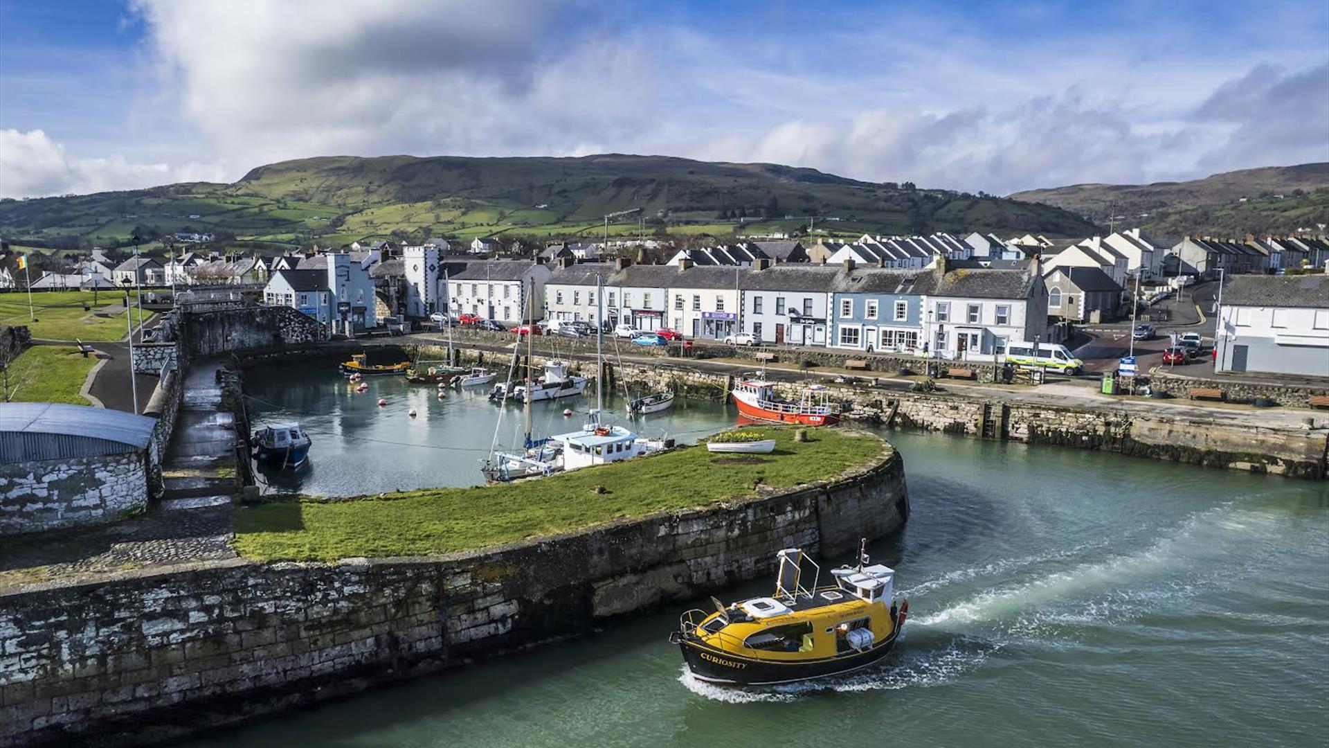 Curiosity boat leaving historical Carnlough harbour