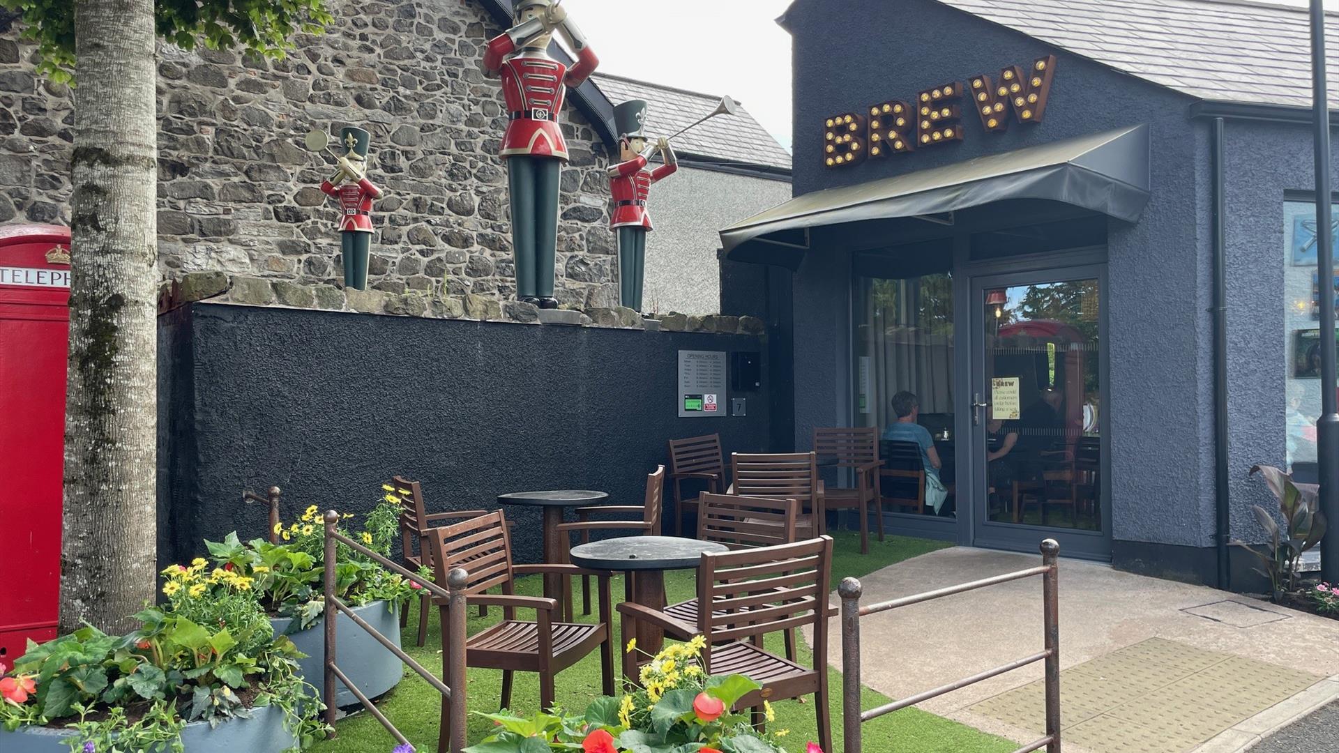 Exterior of Brew Coffee Shop with seating area and herald trumpeters