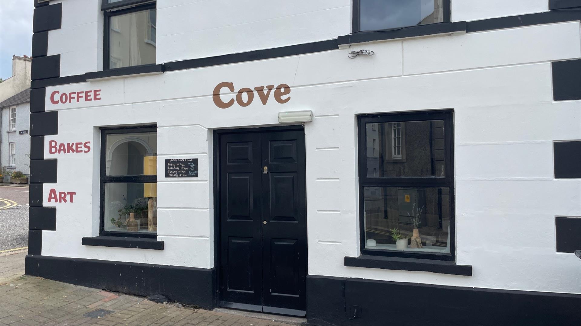 Black and White exterior of Cove Coffee Shop with words painted for Coffee Bakes and Art