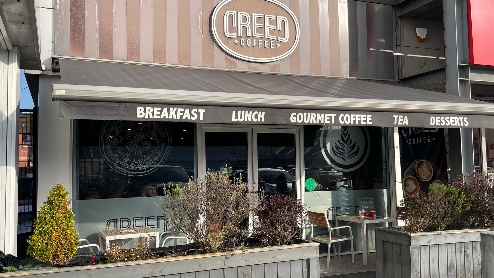 Exterior of Creed Coffee in Larne with outdoor seating area, and grey canopy