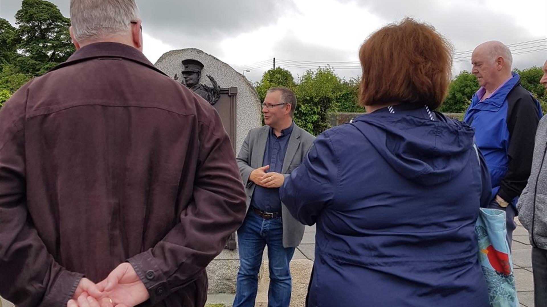 David Hume standing in front of an audience outdoors presenting