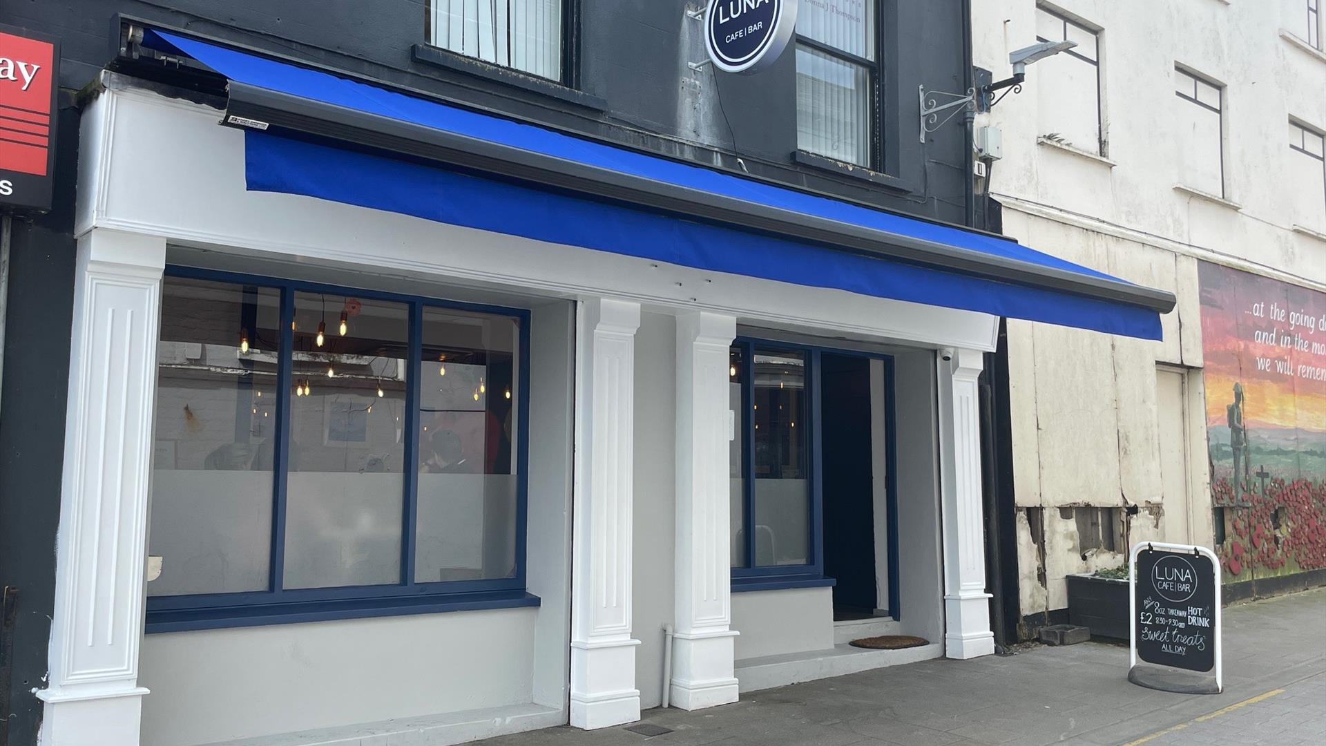 Exterior of Luna Cafe / Bar in Carrickfergus with blue canopy and white pillars