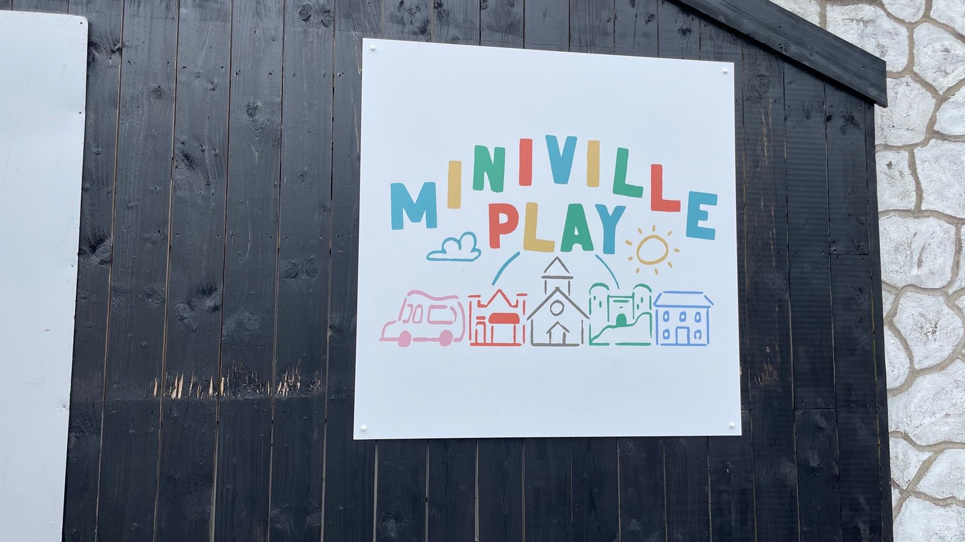 Miniville Play Sign featuring the words plus llustrated images of ice cream van, shop, church, house and castle.