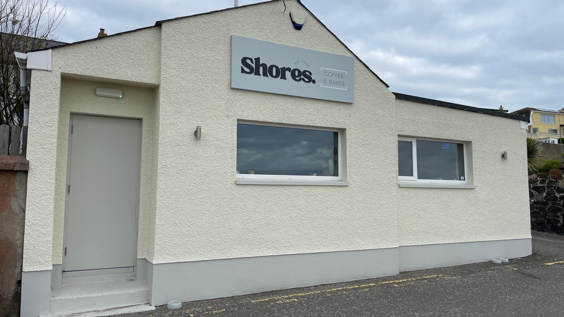 White exterior of Shores. Whitehead with windows facing onto Whitehead promenade.