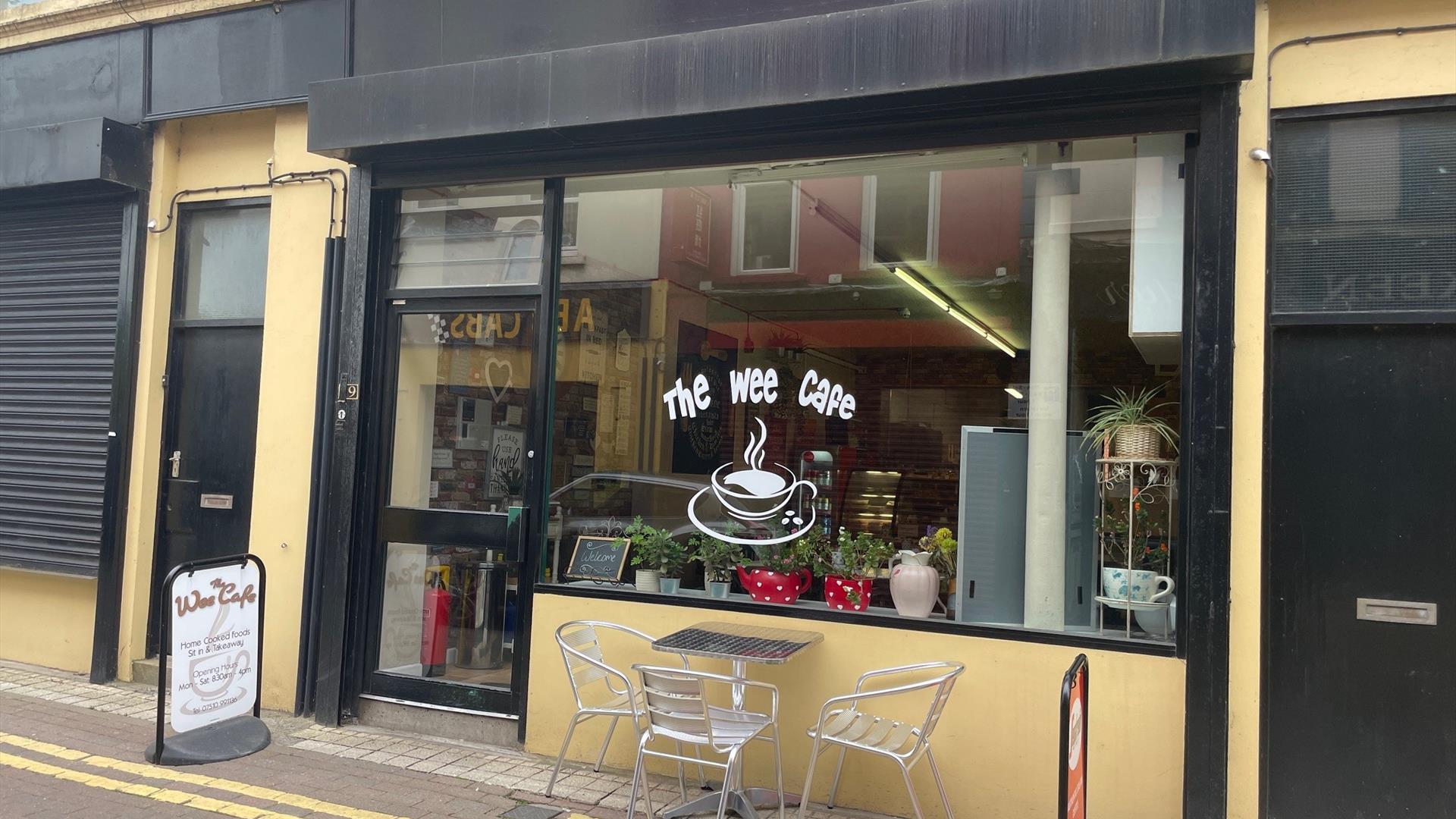 Yellow and Black exterior of the Wee Cafe Larne with name on window and silver outdoor seats