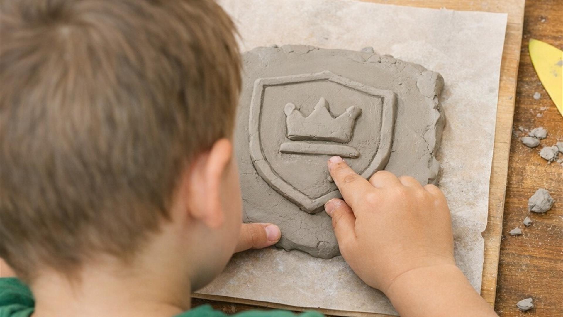 child using clay to make a crest