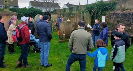 Alastair Donaghy leading a Ballymena Walking Tour with tour participants standing in a graveyard