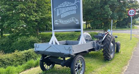 Vintage grey tractor with sign to rear stating Altahammond Wedding Barn